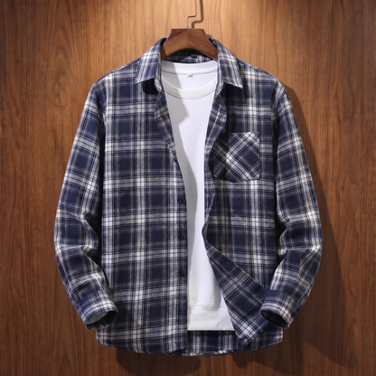 Navy plaid flannel shacket on a wooden hanger