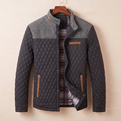 Black diamond quilted jacket with tweed shoulder yoke on a wooden hanger
