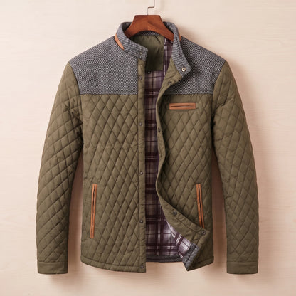 Green diamond quilted jacket with tweed shoulder yoke on a wooden hanger