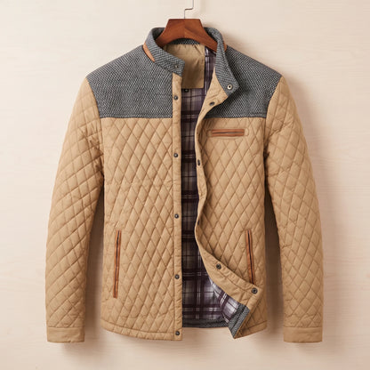 Khaki diamond quilted jacket with tweed shoulder yoke on a wooden hanger
