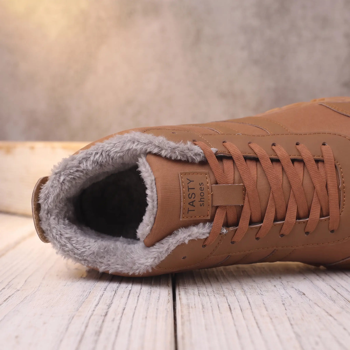 Close-up of the plush fleece collar and laces on the brown winter boot