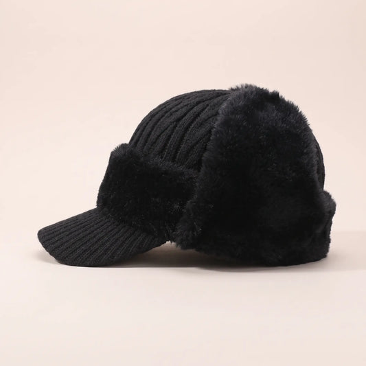 Men's black plush earflap beanie with cable knit crown, short knitted peak and fleece-lined ear flaps, side view