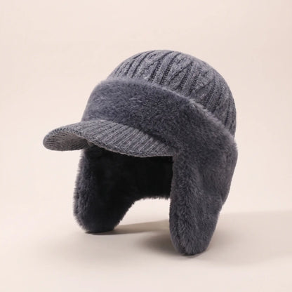Front three-quarter view of grey plush earflap beanie with ear flaps down and fleece lining visible