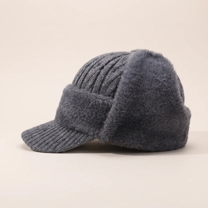 Men's grey plush earflap beanie with cable knit crown, short knitted peak and fleece-lined ear flaps, side view