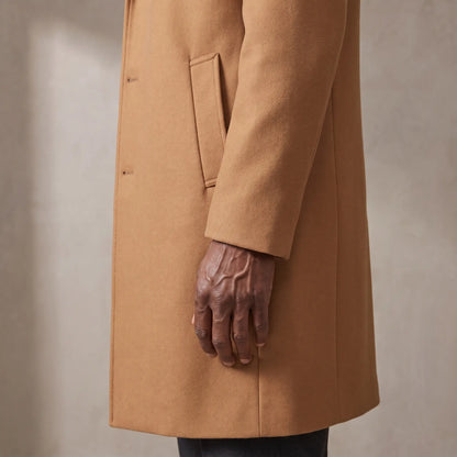 Close up of the sleeve cuff, hip welt pocket and hem of the wool overcoat