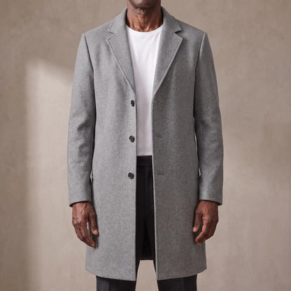 Grey long wool overcoat with quilted lining worn open over a white tee