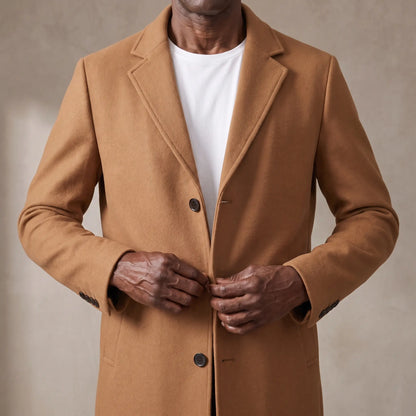 Man buttoning the tan wool overcoat at the chest