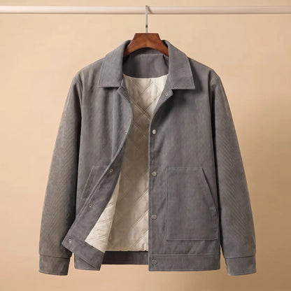 Gray quilted corduroy jacket on a wooden hanger showing the cream quilted lining