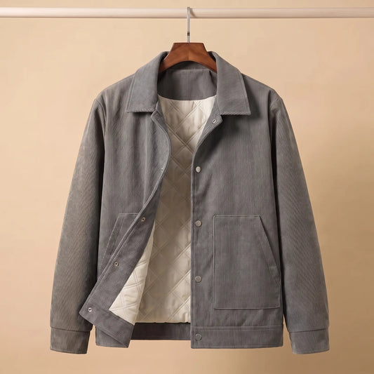 Gray quilted corduroy jacket on a wooden hanger showing the cream quilted lining
