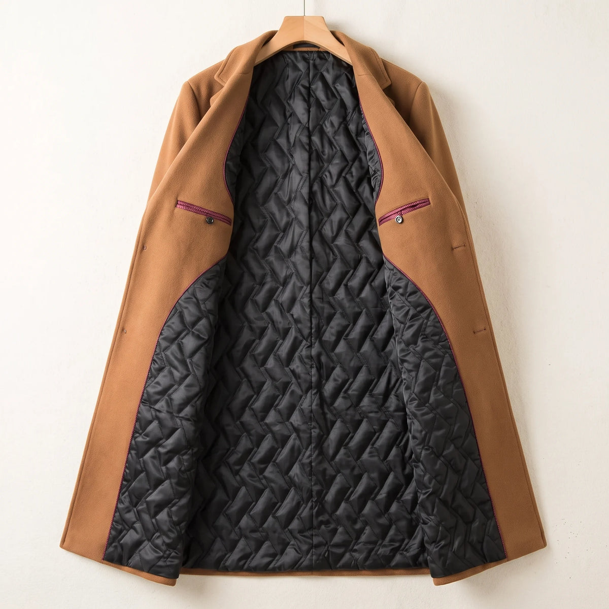 Inside of the quilted lining overcoat showing black quilted lining, burgundy piping and two inside pockets