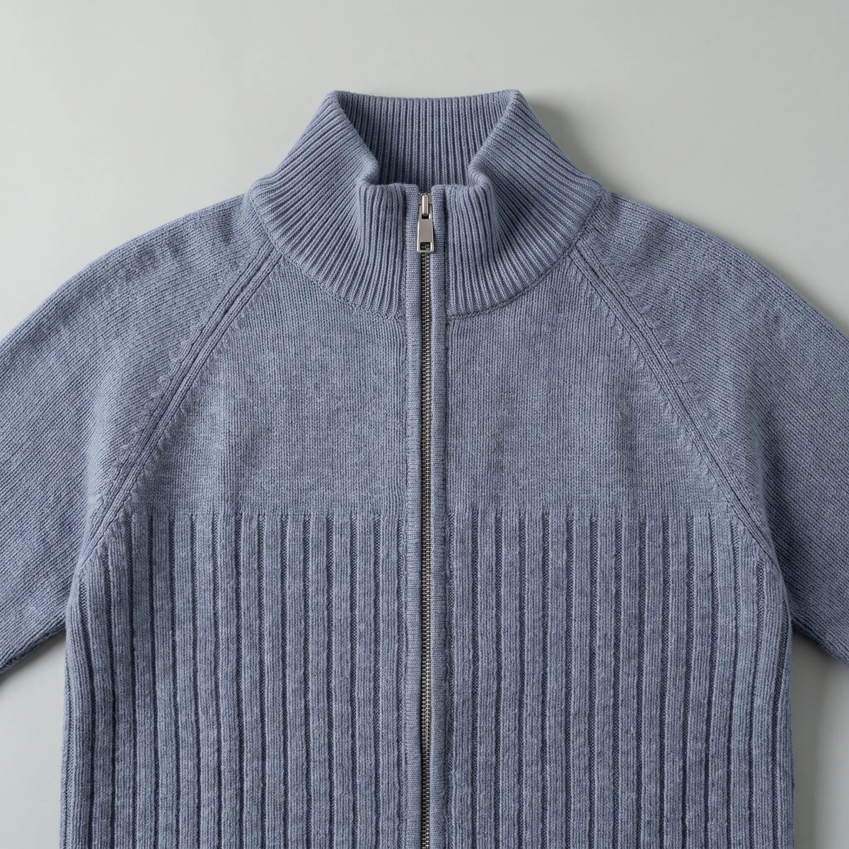 Close up of the tall stand collar, metal zip and ribbed chest of the raglan rib cardigan
