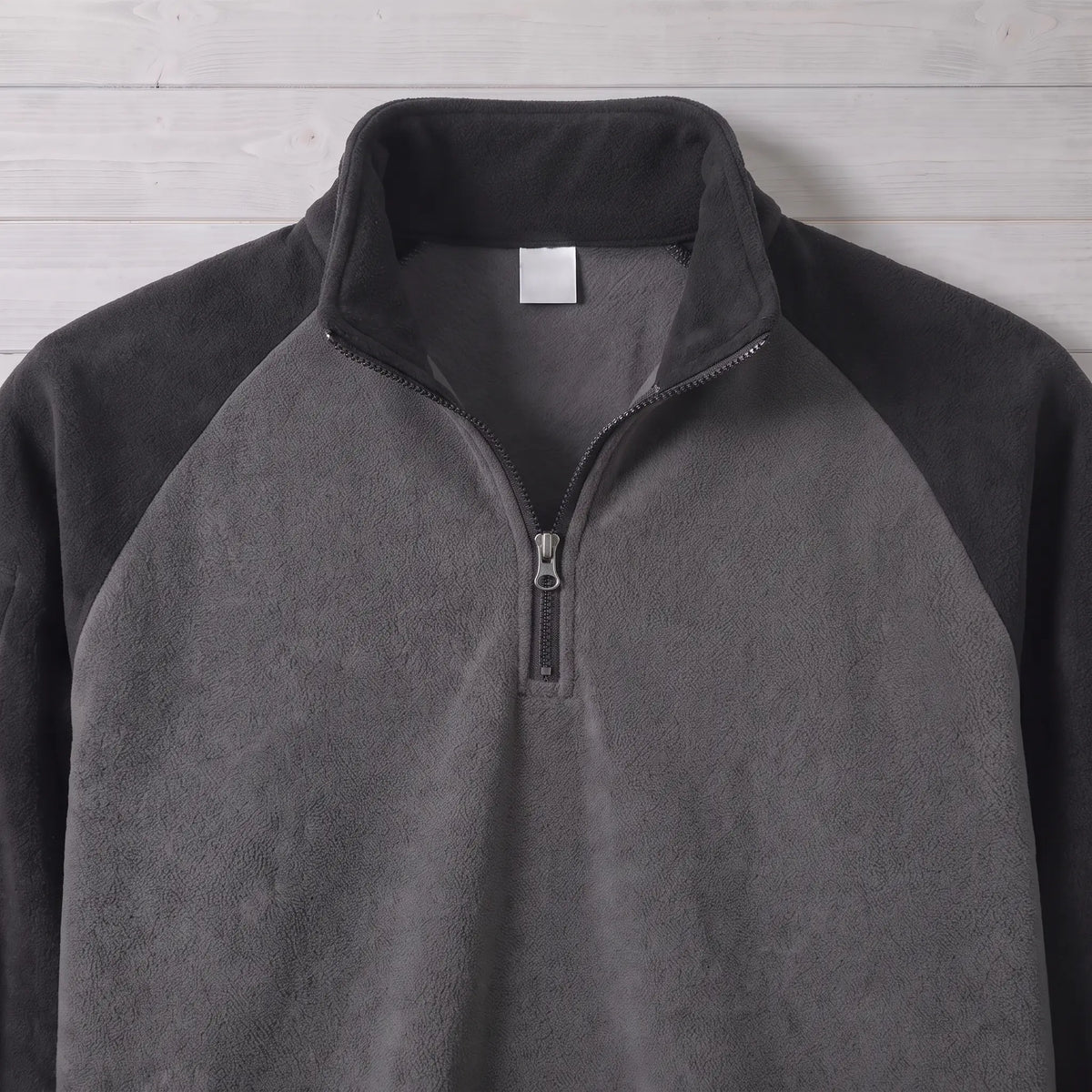 Close up of the RAGLAN ZIP FLEECE stand collar, quarter zip and raglan seams