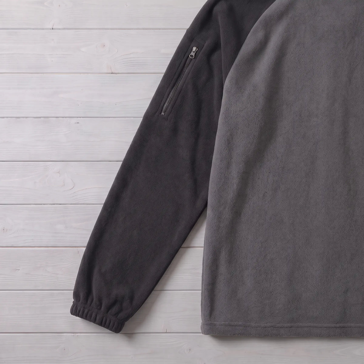 Close up of the RAGLAN ZIP FLEECE sleeve zip pocket and elastic cuff