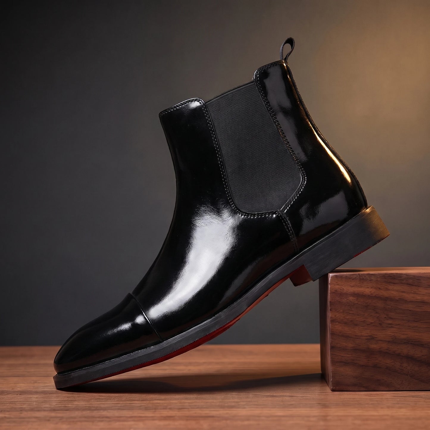 RED SOLE BOOTS in glossy black patent, red-sole Chelsea boot, pedestal hero