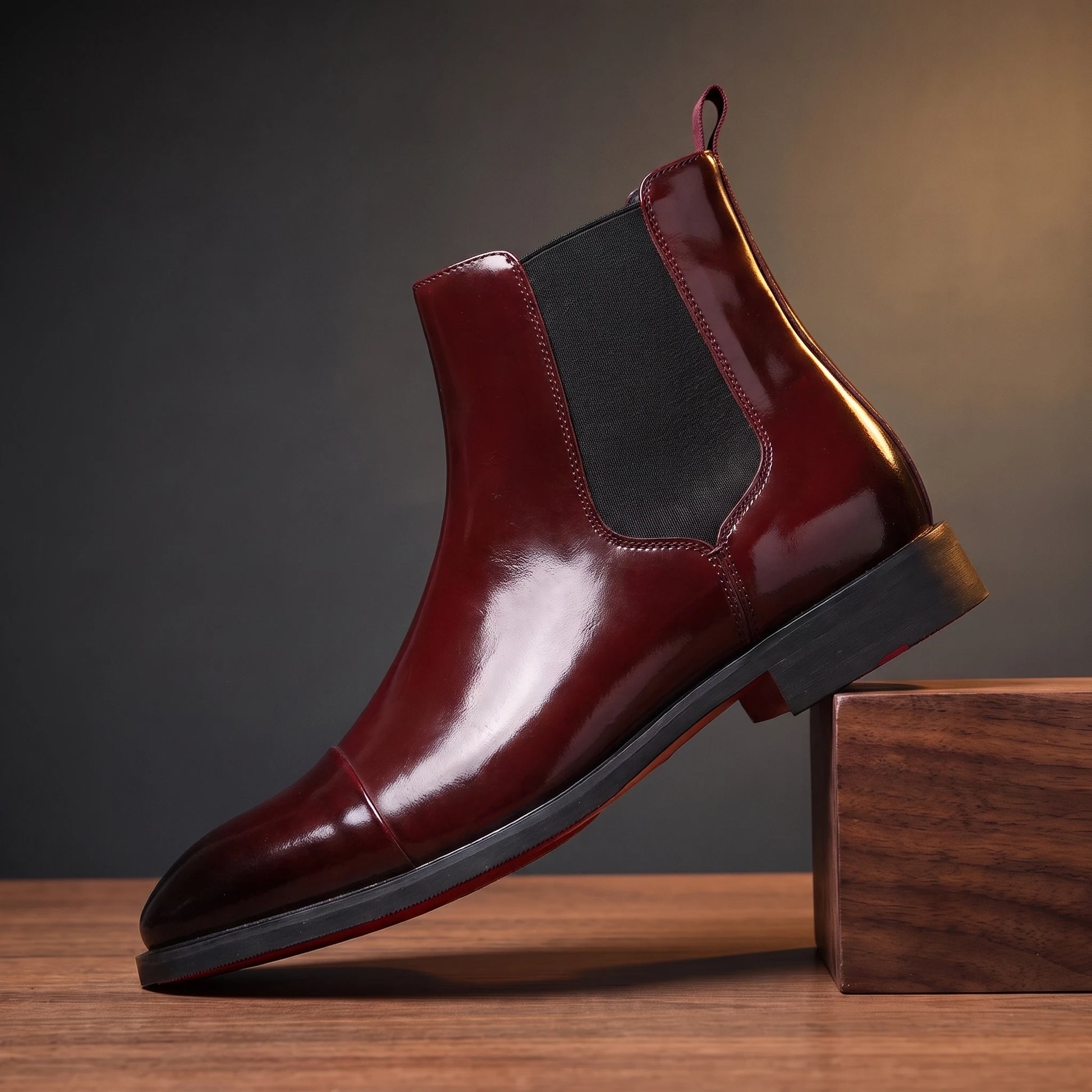 RED SOLE BOOTS in glossy burgundy, red-sole Chelsea boot, pedestal hero