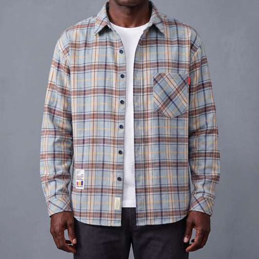 Blue plaid brushed flannel shirt worn open over a white tee by an older man
