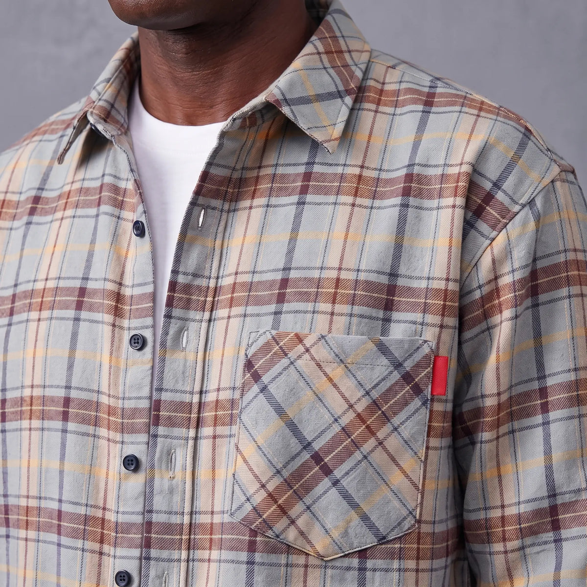 Close-up of the flannel shirt chest pocket, red tab and navy buttons