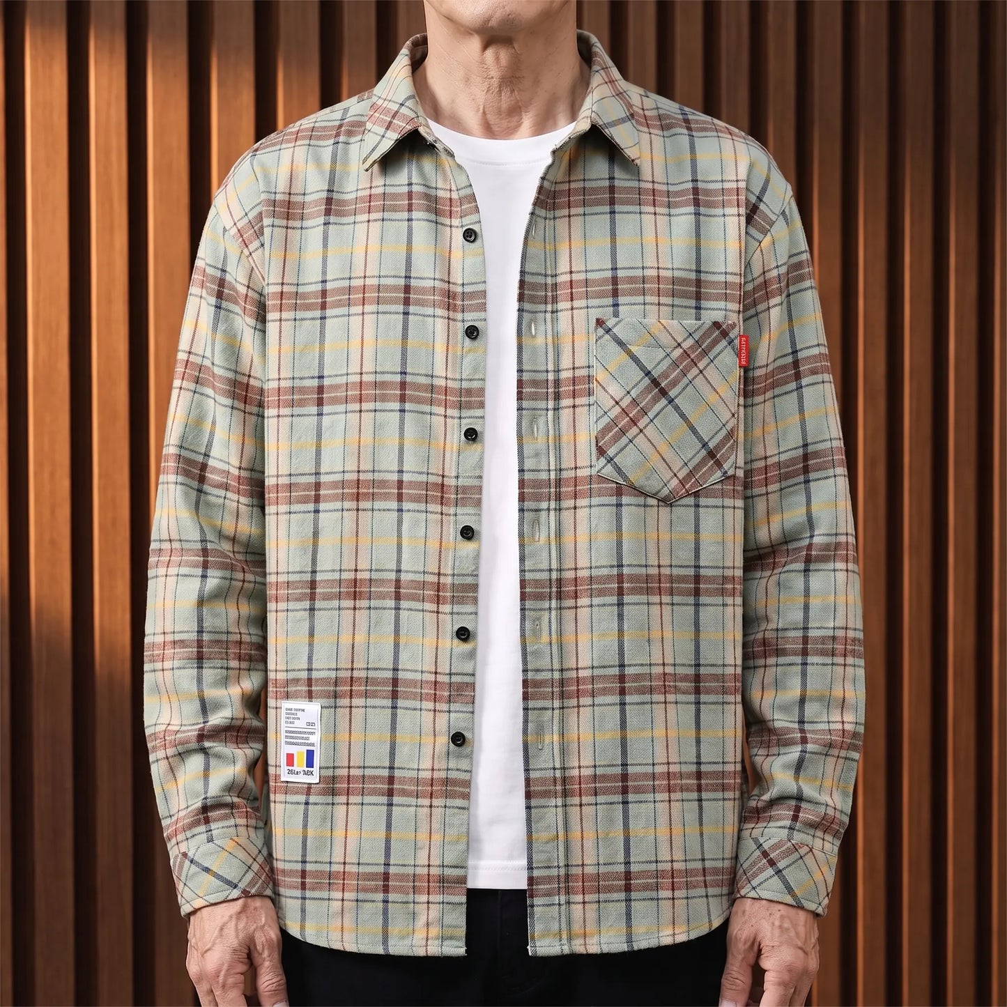 Green plaid brushed flannel shirt worn open over a white tee by an older man