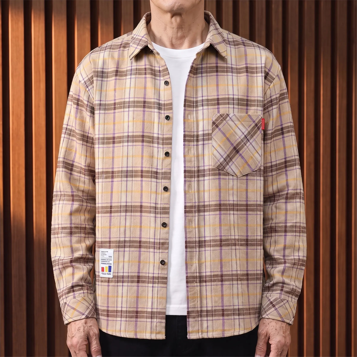 Khaki plaid brushed flannel shirt worn open over a white tee by an older man