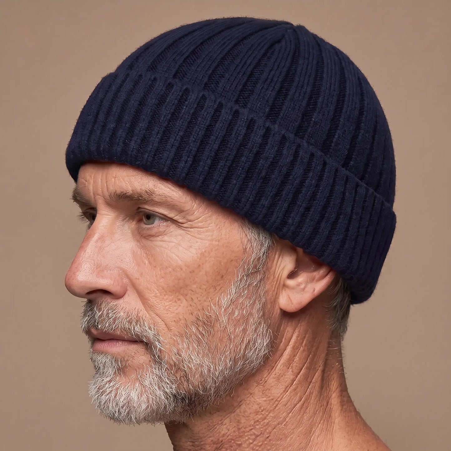 Ribbed docker beanie in navy worn side profile by an older man