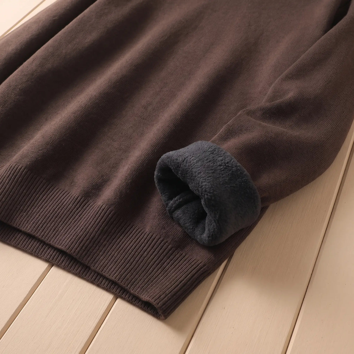 Close-up of the fleece lining at the cuff of the brown roll neck sweater