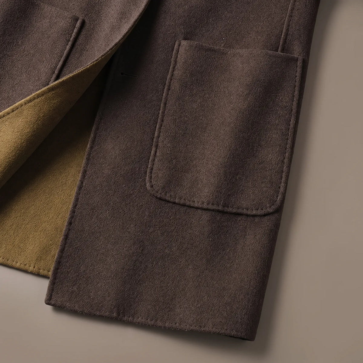 Close up of the SHAWL HOOD COAT hip patch pocket, hem and contrast front edge