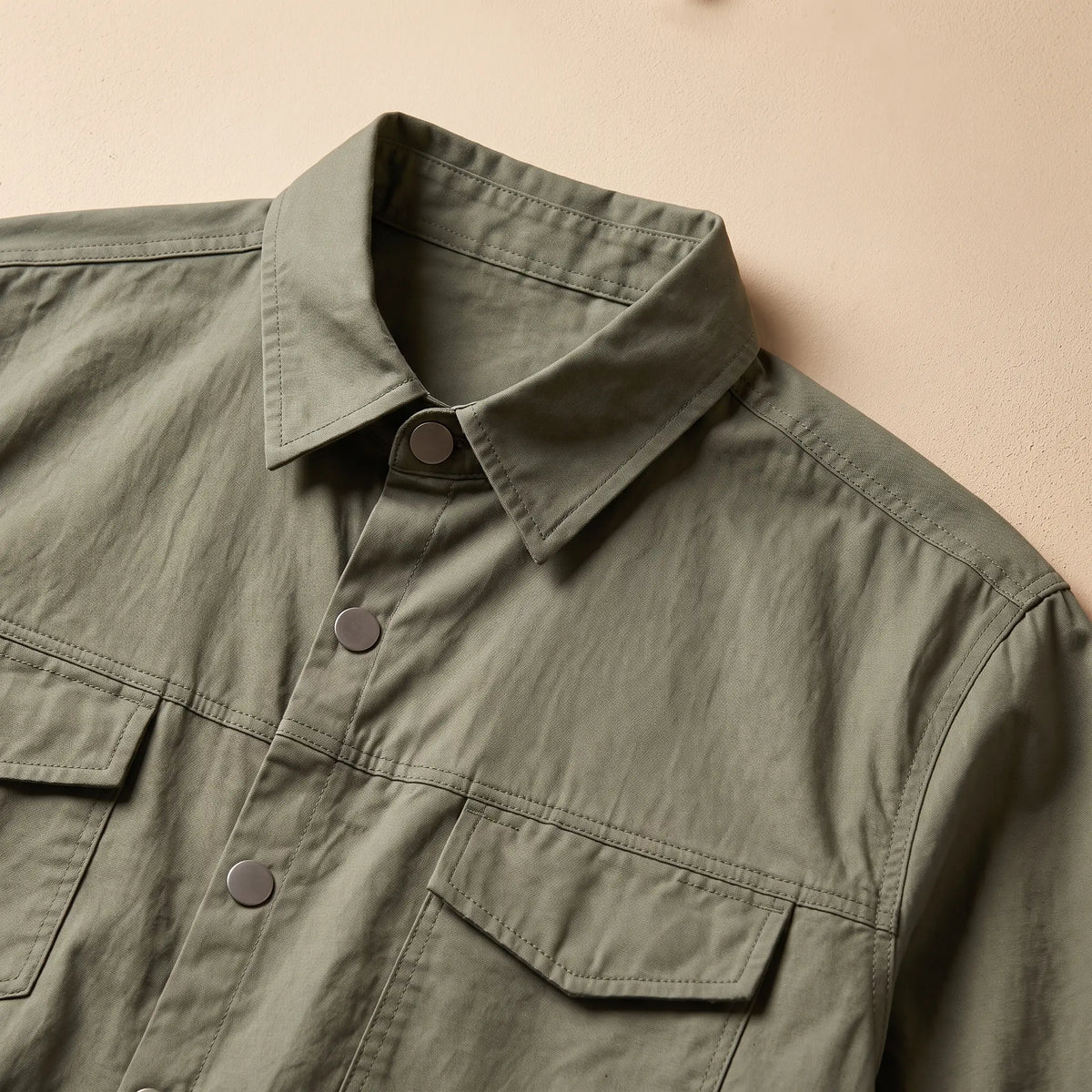 Close up of the collar, placket buttons and flap chest pocket on the green utility shirt