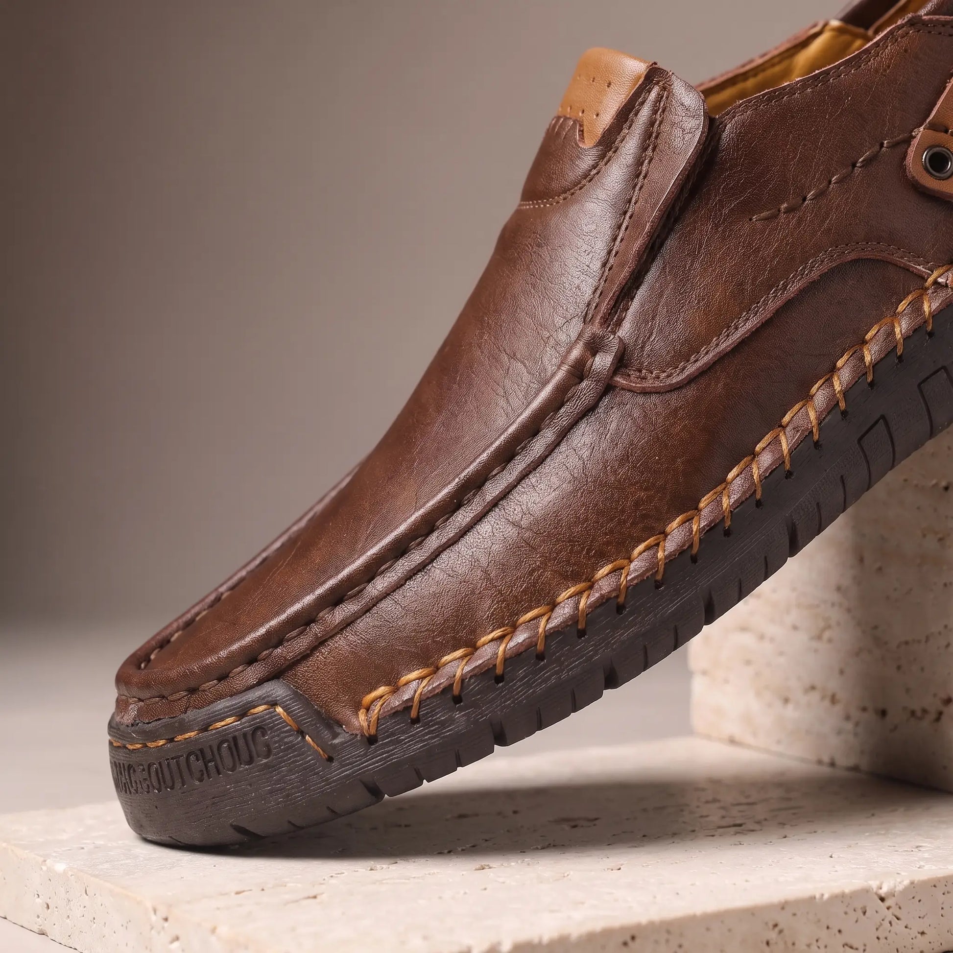 Close up of dark brown side tab loafers showing the hand stitched apron seam and welt