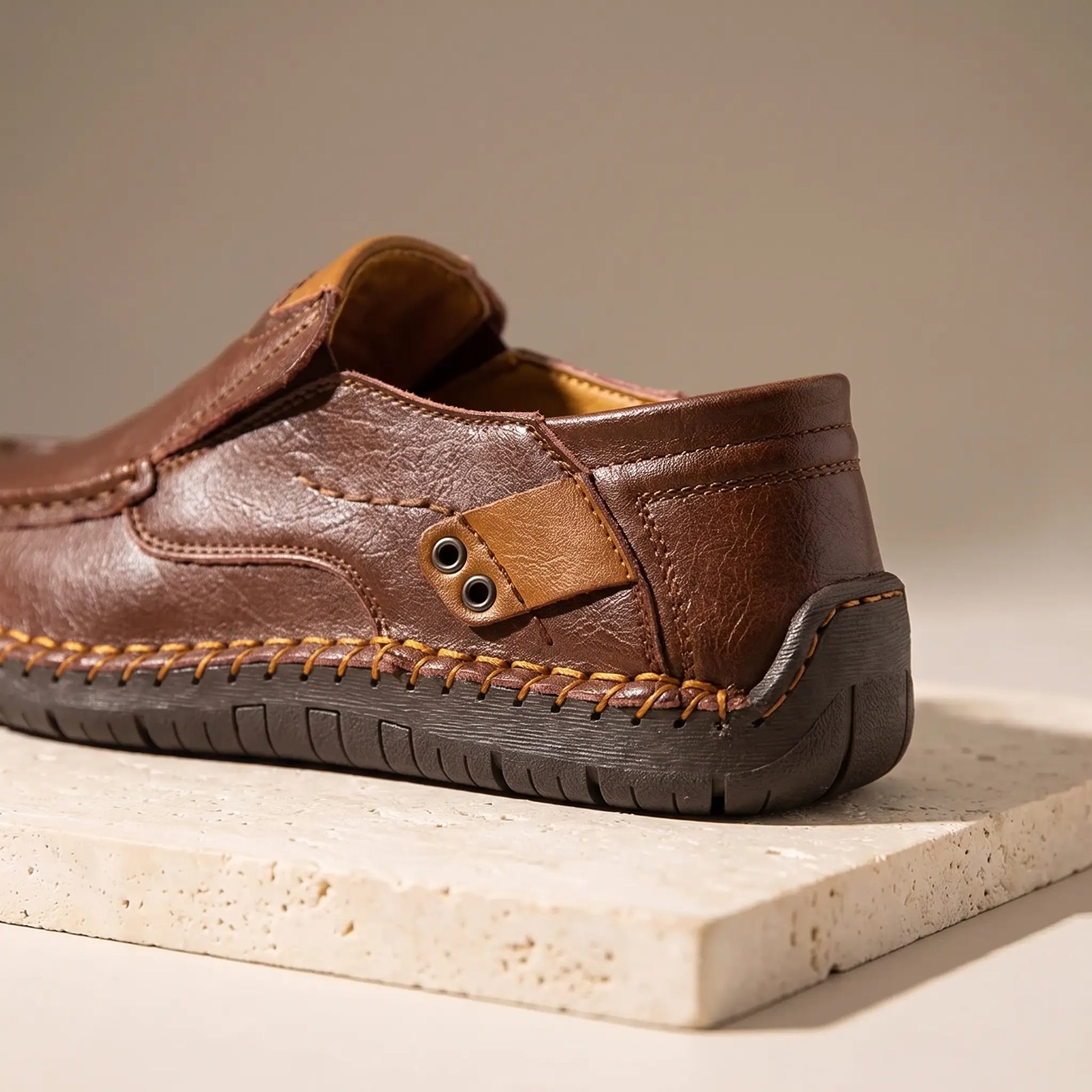 Close up of dark brown side tab loafers showing the leather side tab and metal eyelets