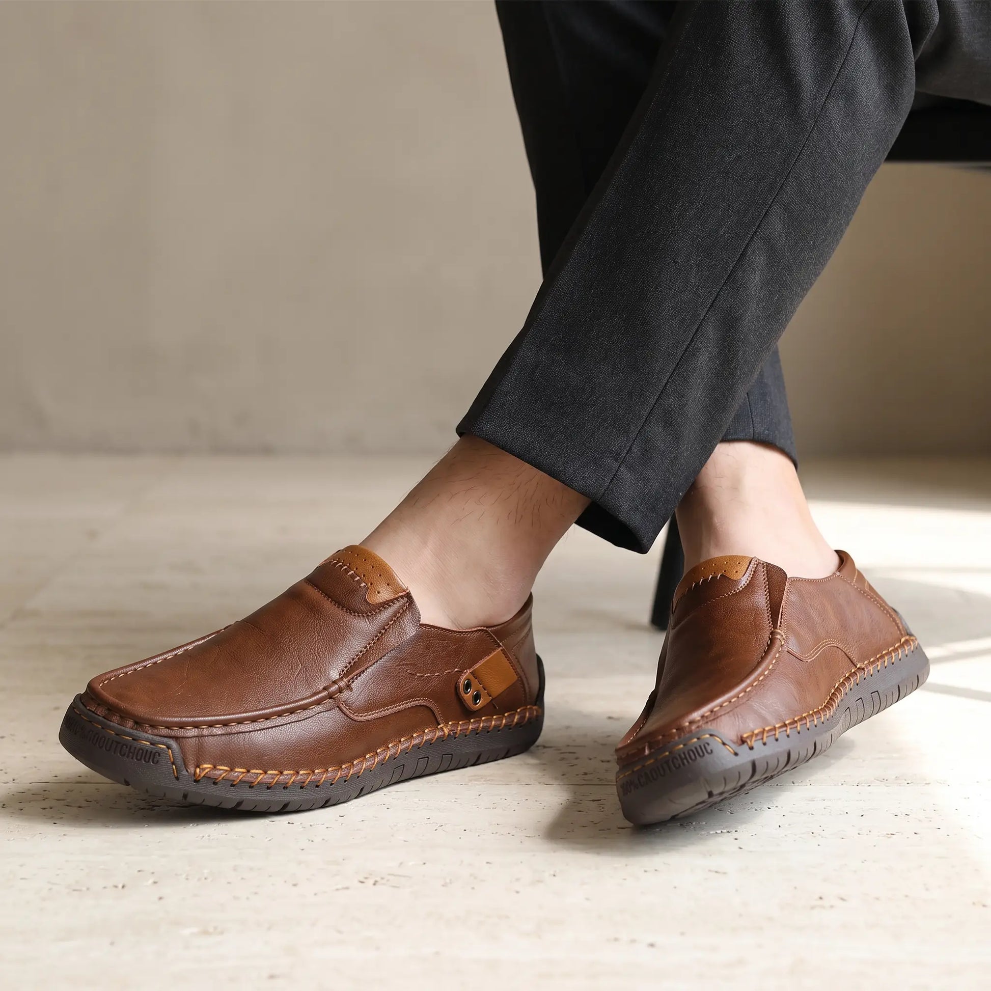 Man wearing dark brown side tab leather loafers with dark tailored trousers