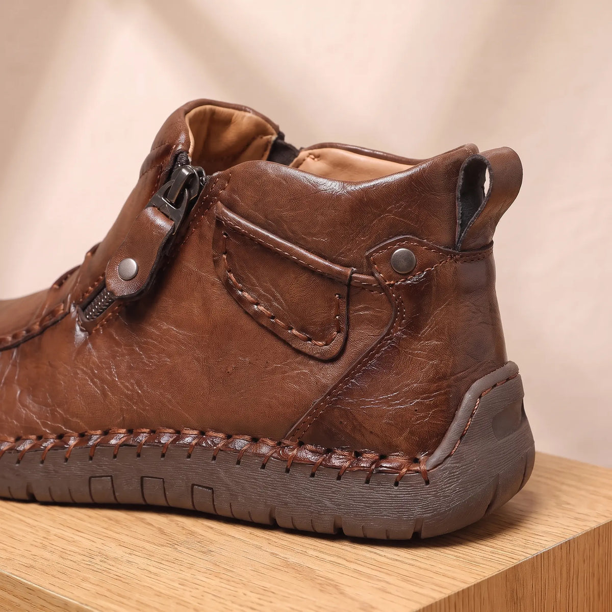 Close up of the SIDE ZIP BOOTS side zip, rivet tab and tan lined collar