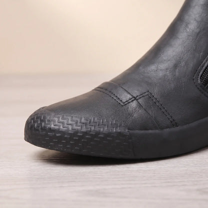 Close up of the textured rubber toe guard on black side zip slip on shoes