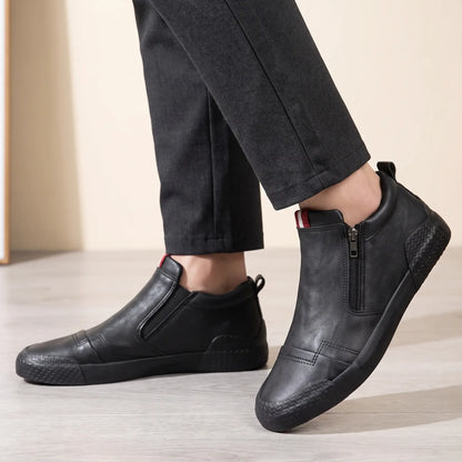 Man wearing black side zip high top slip on shoes with charcoal trousers