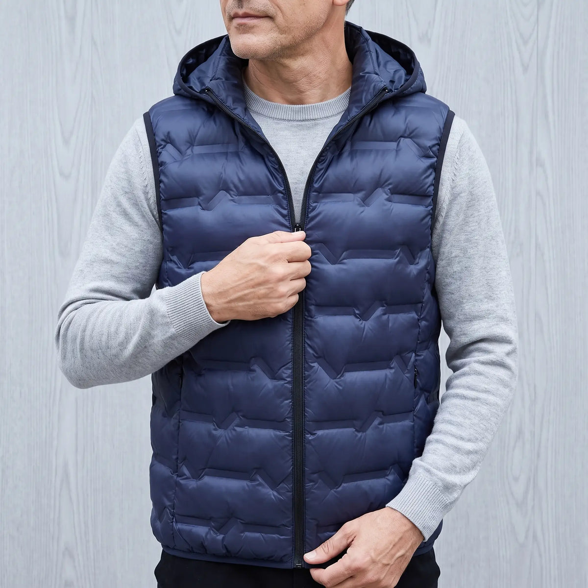 Man zipping up the SILVER LINED PUFFER in navy blue over a grey sweater