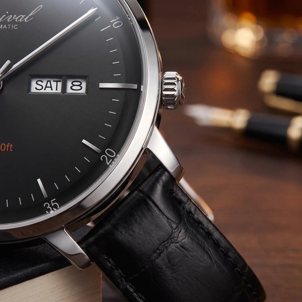Close up of the day and date window and crown on the watch