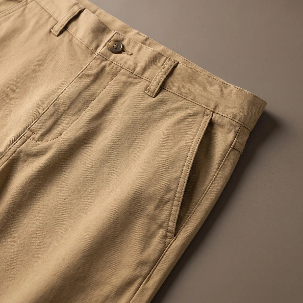 Close up of the SLIM COTTON CHINOS waistband, button and slanted front pocket