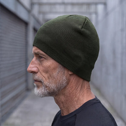 Smooth knit beanie in green worn side profile by an older man