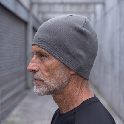 Smooth knit beanie in grey worn side profile by an older man