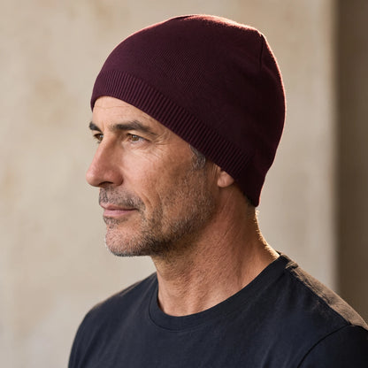 Smooth knit beanie in burgundy, close fit pulled down over the ears, men's winter beanie shown in side profile