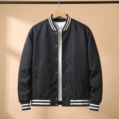 Men's black snap-front baseball bomber jacket with white-striped rib collar, cuffs and hem on a wooden hanger