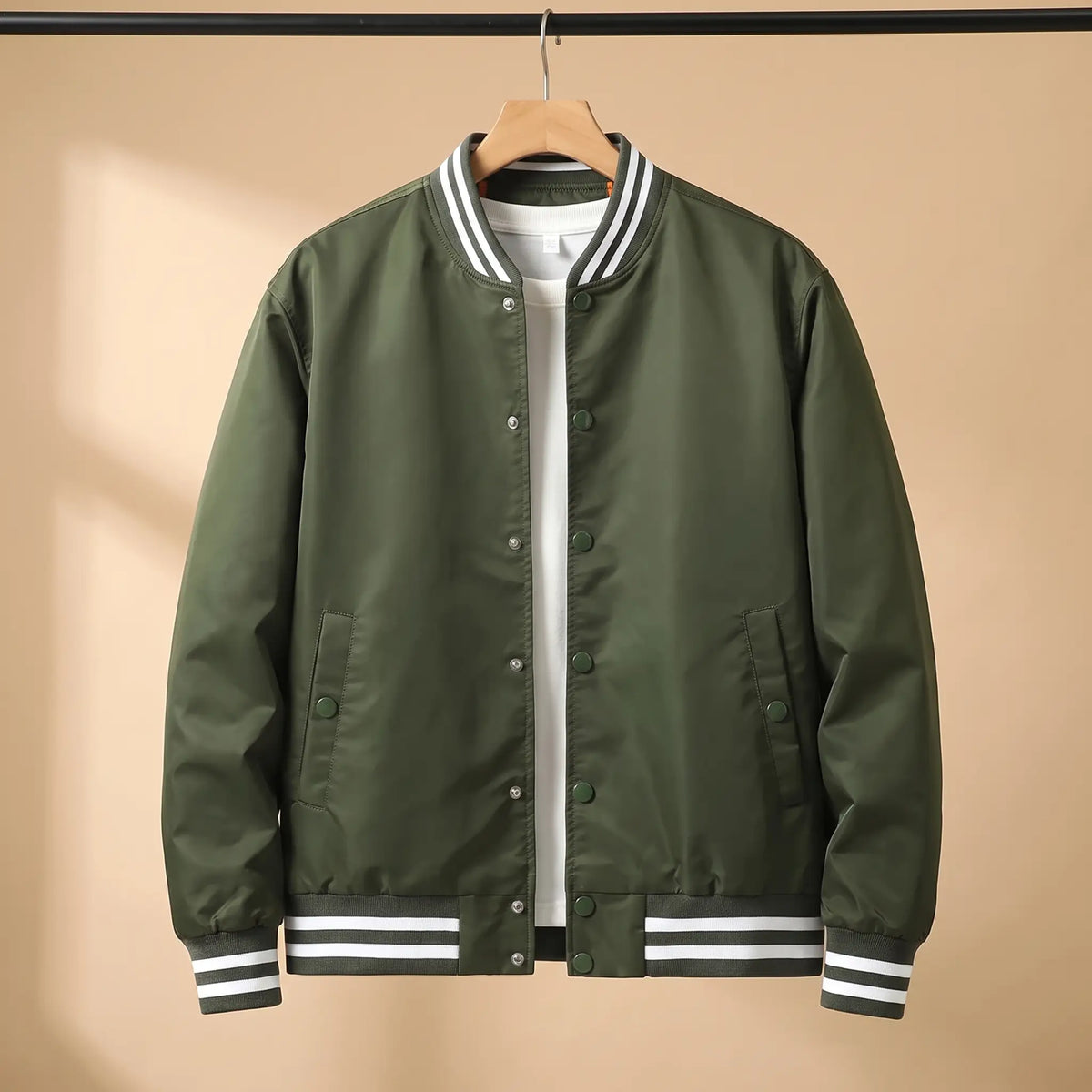 Men's green snap-front baseball bomber jacket with white-striped rib collar, cuffs and hem on a wooden hanger