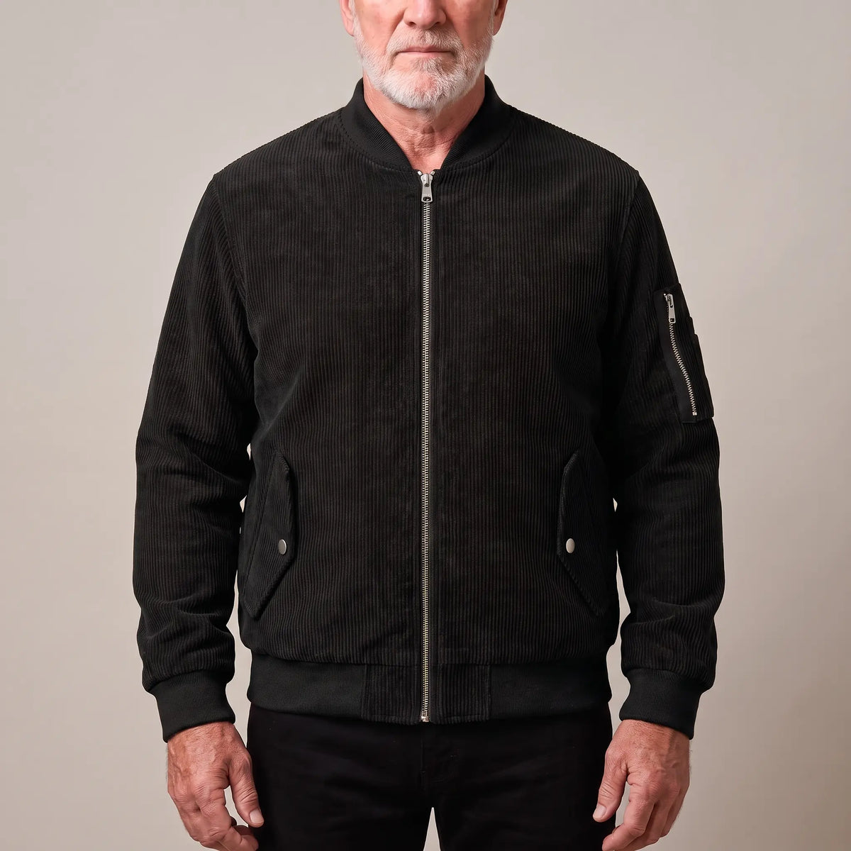 Men's black corduroy bomber jacket with ribbed collar and snap-flap pockets, worn zipped