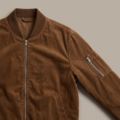Close up of the ribbed collar and zipped sleeve pocket on the brown snap pocket bomber