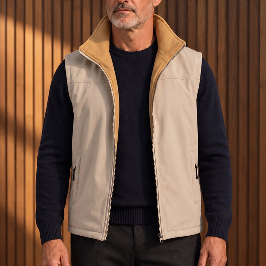 Men's beige softshell vest with camel fleece lining, worn open over a navy sweater