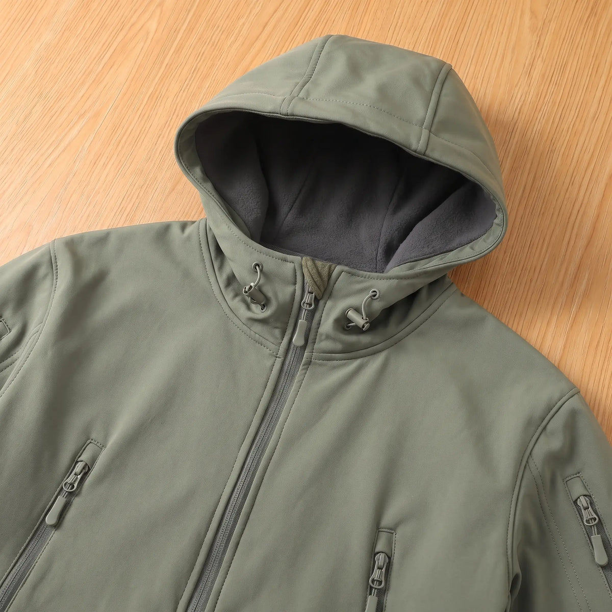 Close-up of the green softshell jacket hood, lining and chest zip pockets