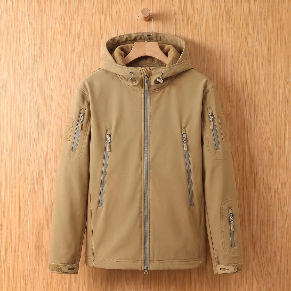 Men's khaki softshell hooded jacket with zip chest pockets on a wooden hanger
