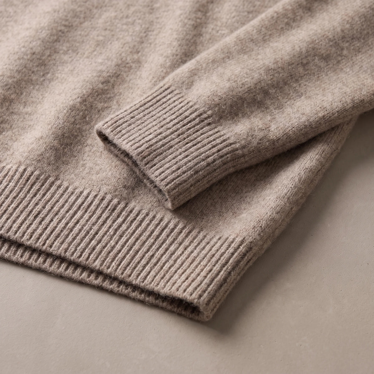 Ribbed cuff and ribbed hem of the fuzzy knit sweater laid flat