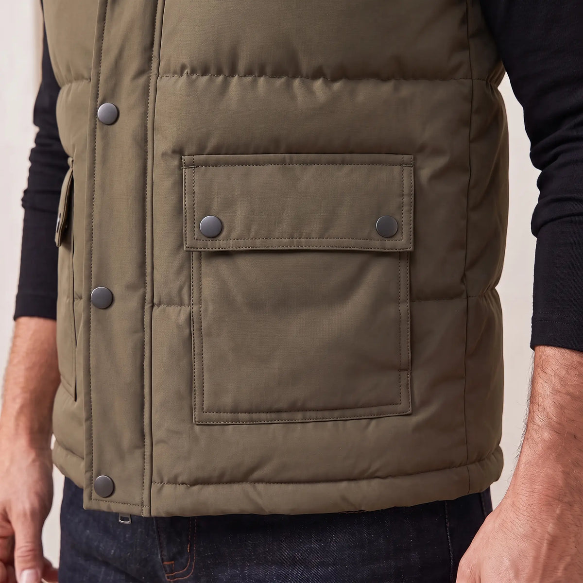 Close up of the snap flap pocket, quilted panels and hem on Stand Collar Vest