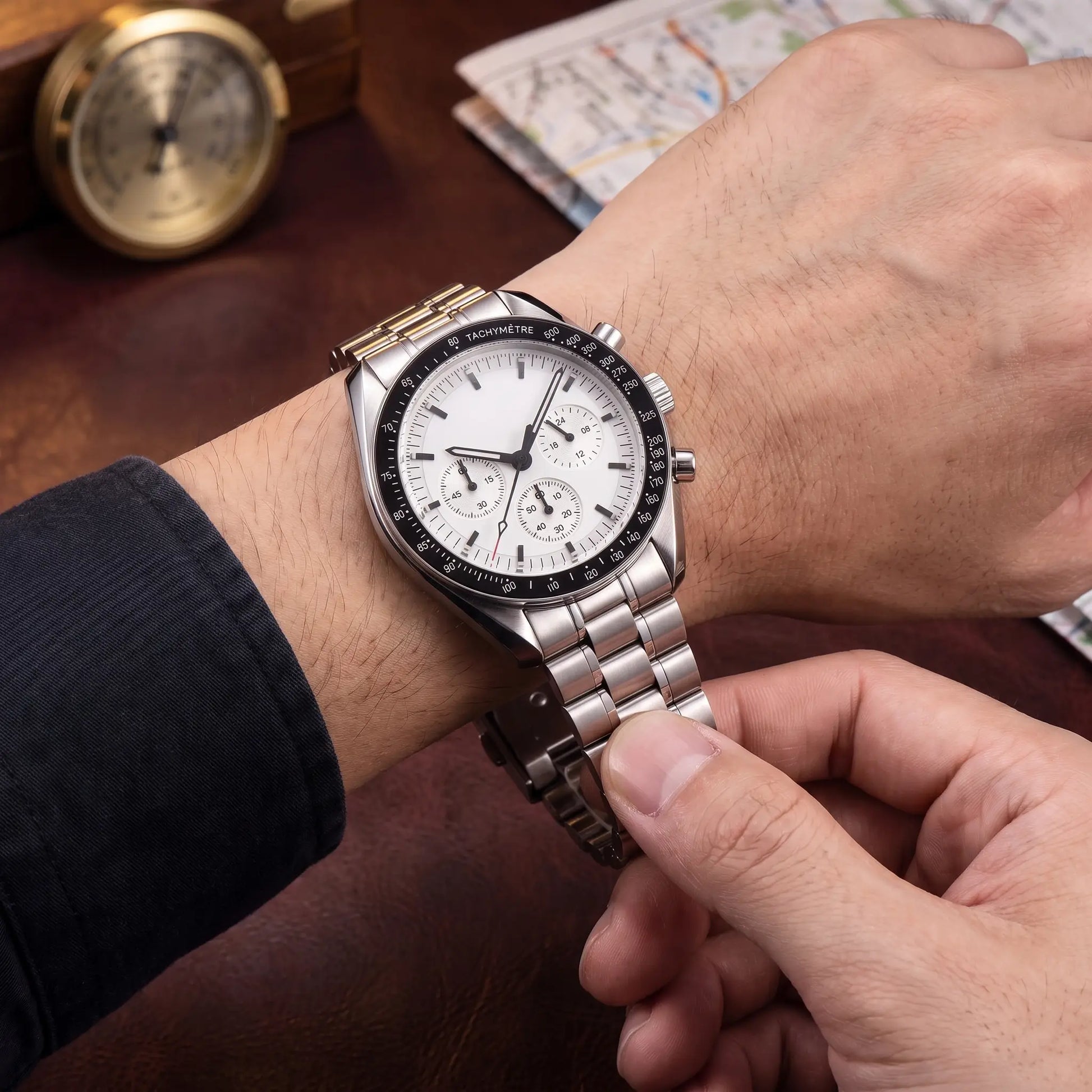 STEEL CHRONOGRAPH WATCH worn on the wrist - fastening the steel bracelet clasp on the white dial chronograph