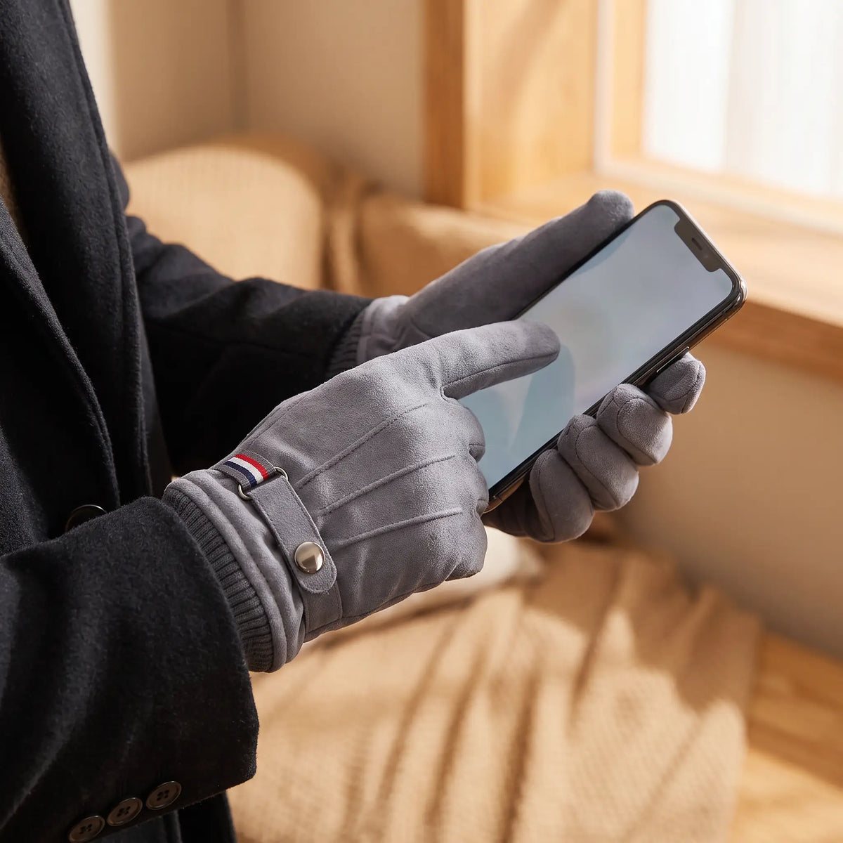 Strap Cuff Gloves in Grey worn while using a phone